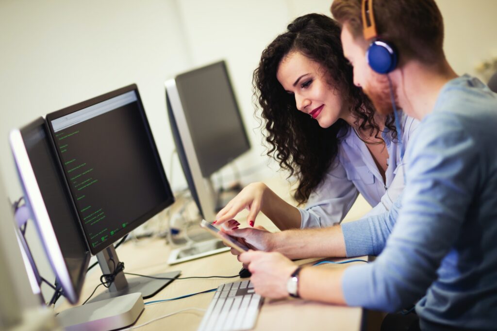 Programmers cooperating at information technology company