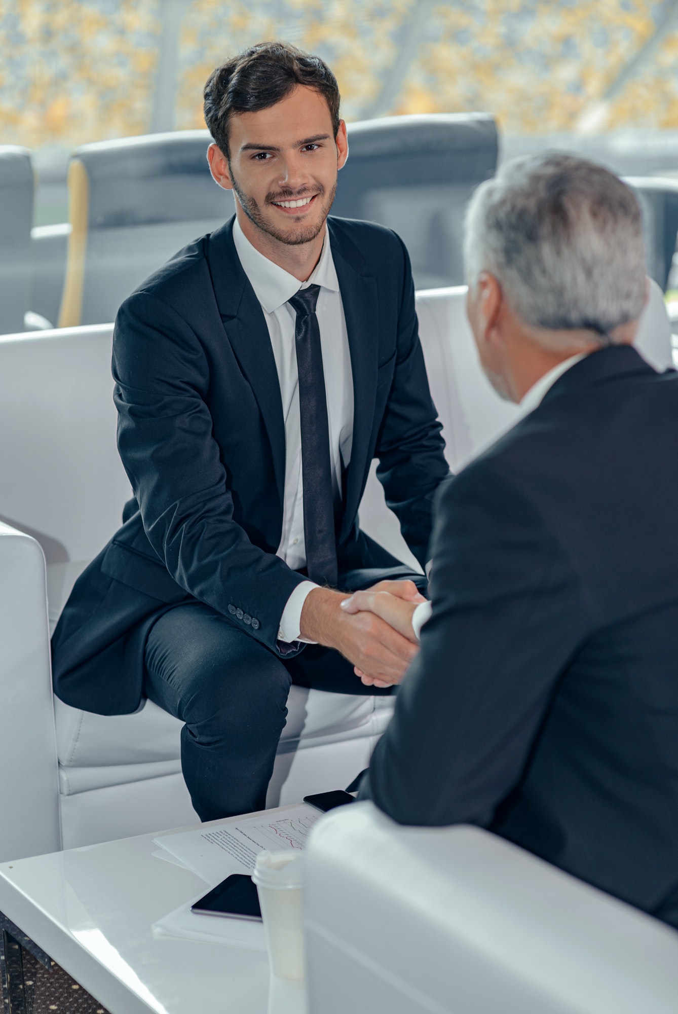 Vertical photo of business men shaking hands in office