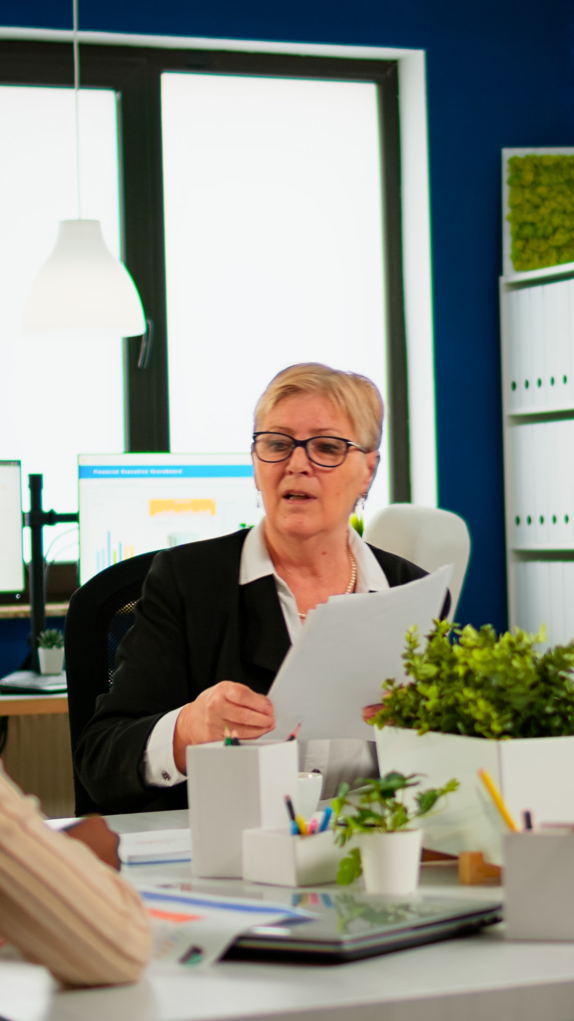 Woman secretary bringing documents and coffee to executive director